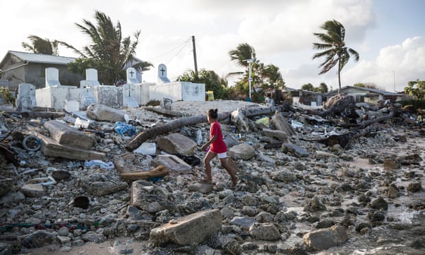 A girl walks past the cemetery in Jenrok village on the Majuro atoll, the capital of the Marshall Islands. During high tides the cemetery and some of the nearby houses become inundated. Photograph: Vlad Sokhin/World Bank