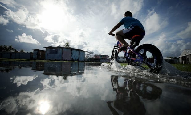 A boy rides through floodwaters near high tide in a low-lying area of Tuvalu, in the South Pacific. Pacific island leaders have expressed disappointment at the Cop26 climate summit’s outcome. Photograph: Mario Tama/Getty Images